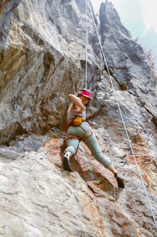Escaladora en la pared de roca naranja